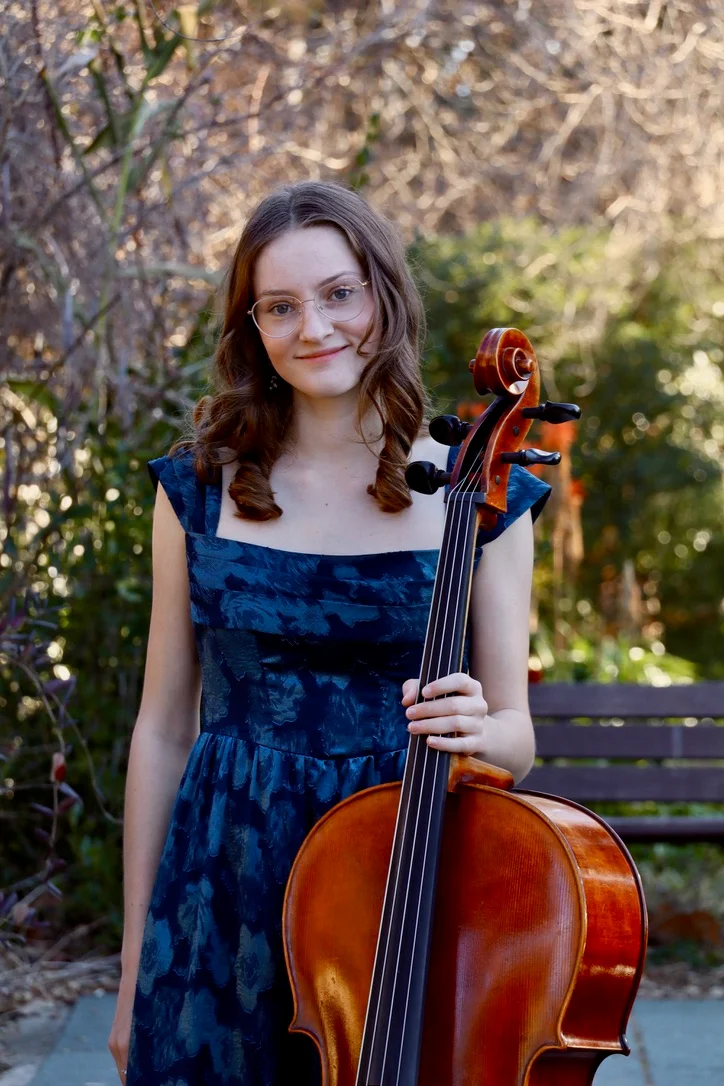 Joanna holding her cello in a garden